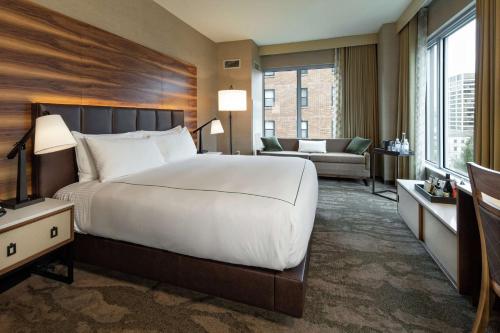 a bedroom with a large bed and a living room at The Porter Portland, Curio Collection By Hilton in Portland