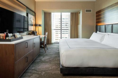a hotel room with a large bed and a bathroom at The Porter Portland, Curio Collection By Hilton in Portland