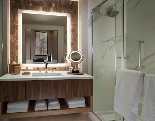 a bathroom with a sink and a shower at The Porter Portland, Curio Collection By Hilton in Portland