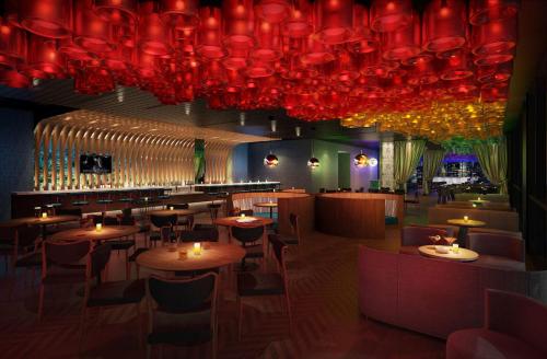 a restaurant with tables and chairs and red chandeliers at The Porter Portland, Curio Collection By Hilton in Portland