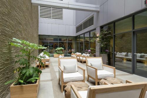 a patio with chairs and tables in a building at The Porter Portland, Curio Collection By Hilton in Portland