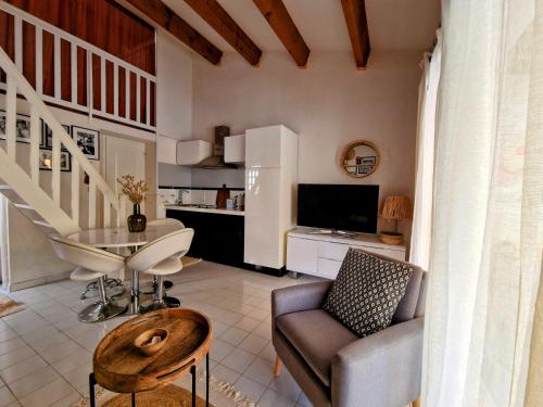 a living room with a couch and a table at Villa à deux pas de la plage Richelieu in Cap d'Agde