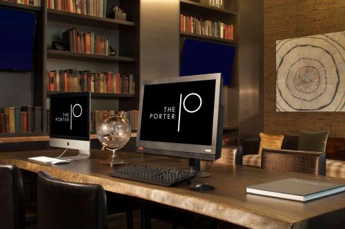 a desk with a computer monitor and a keyboard at The Porter Portland, Curio Collection By Hilton in Portland