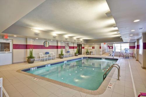 a pool in a large room with a hotel room at Home2 Suites by Hilton KCI Airport in Kansas City