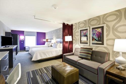 ein Hotelzimmer mit einem Bett und einem Sofa in der Unterkunft Home2 Suites by Hilton KCI Airport in Kansas City