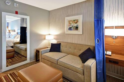 a living room with a couch and a bedroom at Home2 Suites by Hilton Atlanta Norcross in Norcross