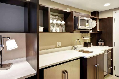 a kitchen with a sink and a microwave at Home2 Suites by Hilton Atlanta Norcross in Norcross