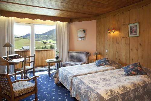 a hotel room with two beds and a balcony at Hotel Christiania in Villard-de-Lans