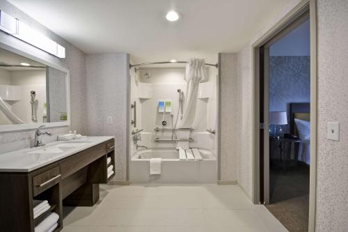 a large bathroom with a tub and a sink at Home2 Suites By Hilton Columbus Airport East Broad in Columbus