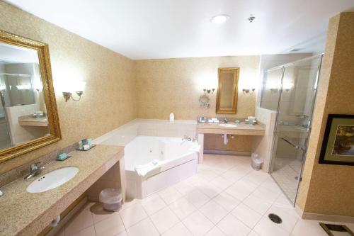 a large bathroom with a tub and a sink and a bath tub at Virginia Crossings Hotel, Tapestry Collection by Hilton in Richmond