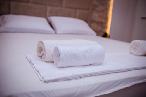 two rolls of white towels on a bed at Apartment Stone Mostar in Mostar