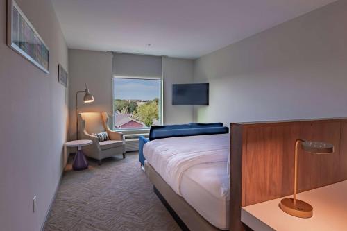 um quarto de hotel com uma cama e uma cadeira em Hilton Garden Inn Dallas At Hurst Conference Center em Hurst