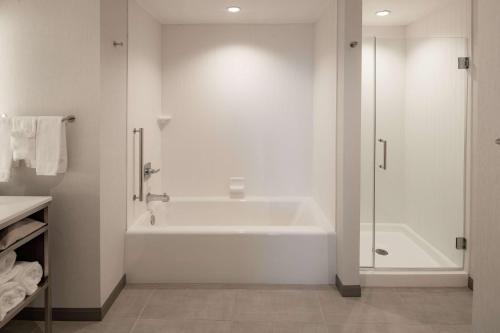 biała łazienka z wanną i prysznicem w obiekcie Hilton Garden Inn Dallas At Hurst Conference Center w mieście Hurst