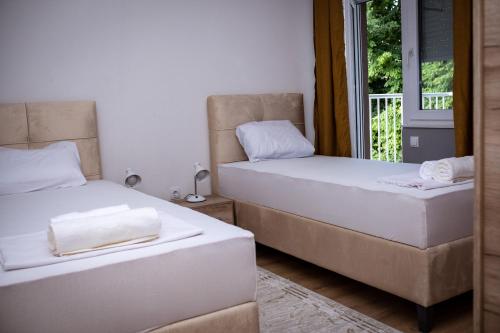 two beds in a room with a window at Apartment Stone Mostar in Mostar