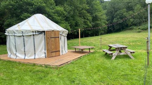 a yurt and a picnic table in a field at La Bastide d'Albignac in Le Dourn