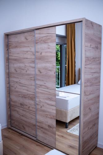 a wooden wardrobe with a mirror in a bedroom at Apartment Stone Mostar in Mostar