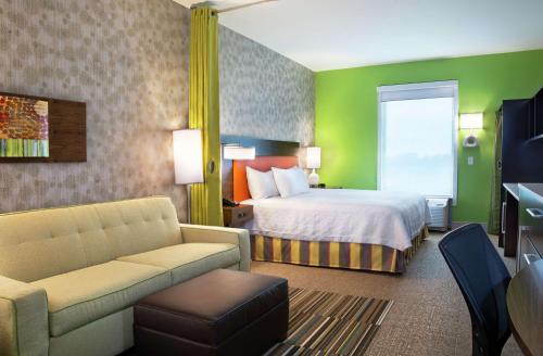 um quarto de hotel com uma cama e um sofá em Home2 Suites By Hilton Indianapolis Greenwood em Indianápolis