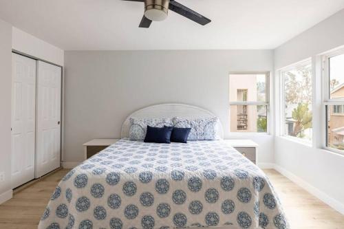 a white bedroom with a bed with blue pillows at Beach Home W AC- 5 BR - Free Parking - EV Charge in San Diego