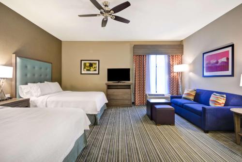 落基山的住宿－洛基山希爾頓惠庭套房酒店，酒店客房,设有两张床和一张蓝色的沙发
