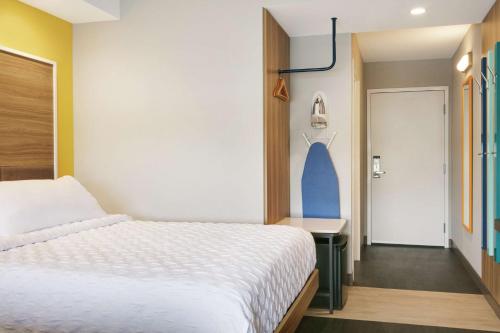 a bedroom with a bed and a hallway with a door at Tru By Hilton Williamsville Buffalo Airport in Williamsville