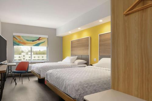 a hotel room with two beds and a desk at Tru By Hilton Williamsville Buffalo Airport in Williamsville