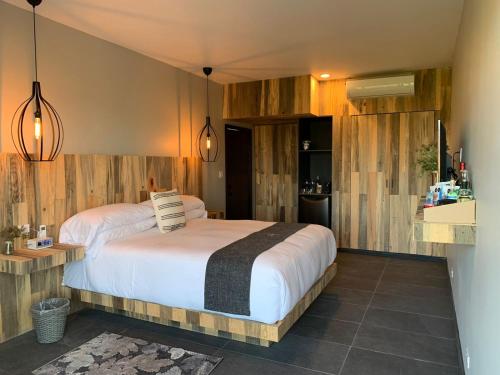 1 dormitorio con 1 cama grande y paredes de madera en Hotel Partana, en Ensenada