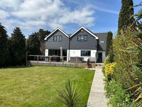 a black and white house with a yard at Luxury Air Conditioned 6 Bedroom Hythe Seaside in Kent