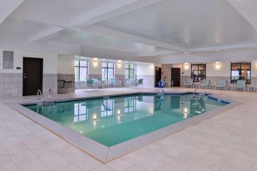 a large swimming pool in a hotel lobby at Homewood Suites Des Moines Airport in Des Moines