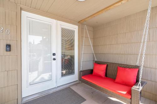 a porch swing with red pillows on a house at ALKI Retreat! Steps-2-BEACH - PARKING in Seattle