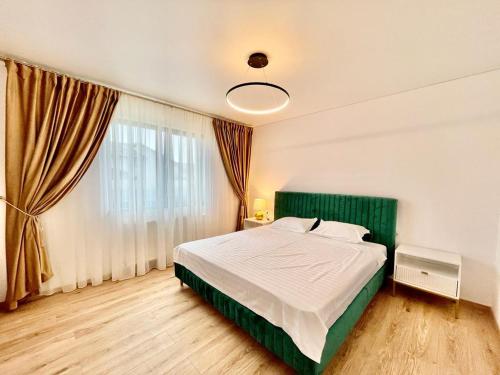 a bedroom with a bed and a large window at Residence Odaile #2 in Otopeni