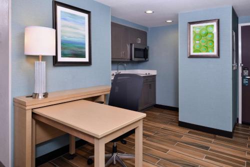 a small room with a desk and a table at Homewood Suites Des Moines Airport in Des Moines