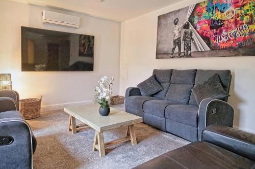 a living room with a couch and a table at Luxury Air Conditioned 6 Bedroom Hythe Seaside in Kent