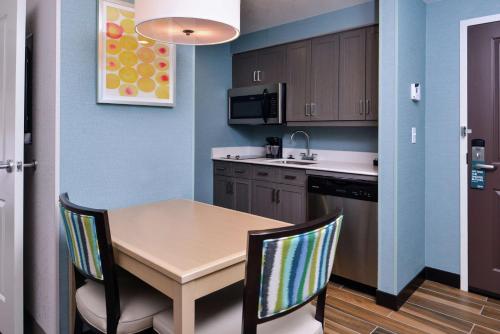 a kitchen with a table and chairs in a room at Homewood Suites Des Moines Airport in Des Moines