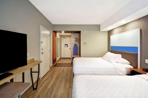 um quarto de hotel com duas camas e uma televisão de ecrã plano em Tru By Hilton Salt Lake City Airport em Salt Lake City