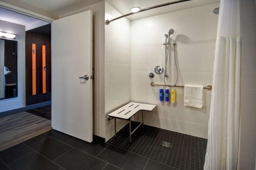 a bathroom with a shower with a bench in it at Tru By Hilton Salt Lake City Airport in Salt Lake City