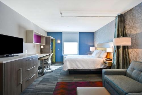 カンザスシティにあるHome2 Suites by Hilton Kansas City KU Medical Centerのベッドとデスクが備わるホテルルームです。