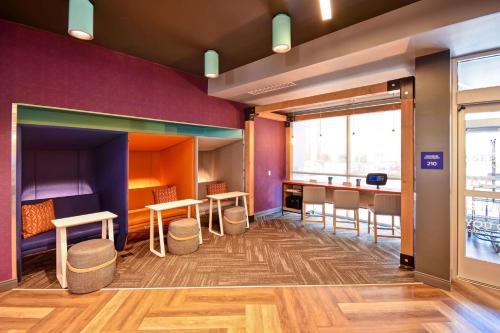 a waiting area with tables and chairs in a room at Tru By Hilton Salt Lake City Airport in Salt Lake City