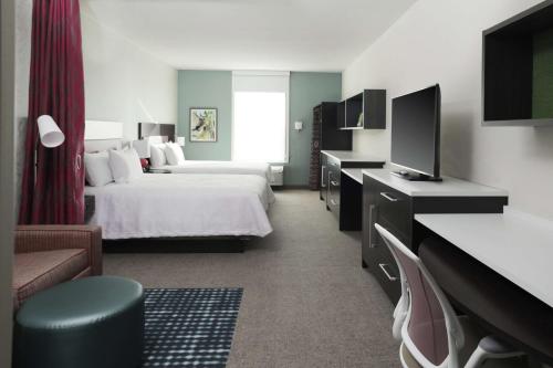 a hotel room with a bed and a television at Home2 Suites By Hilton Louisville Airport Expo Center in Louisville