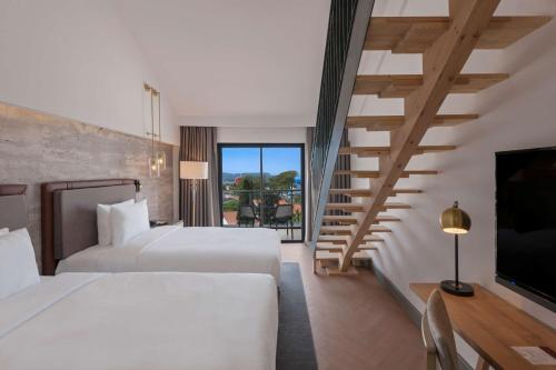 a hotel room with two beds and a staircase at DoubleTree by Hilton Antalya-Kemer All-Inclusive Resort in Kemer