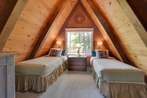 twee bedden in een kamer met een zolder bij Cozy Deer Lake Cabin, 3 Mi to Boyne Mtn Resort! in Boyne City