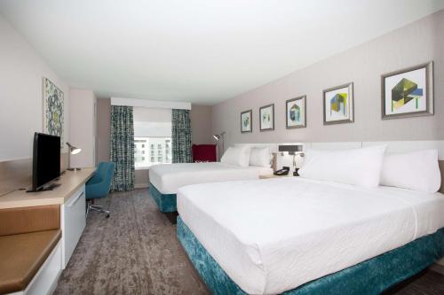a hotel room with two beds and a flat screen tv at Hilton Garden Inn Las Vegas City Center in Las Vegas