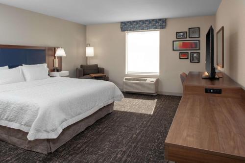 a hotel room with a bed and a television at Hampton Inn & Suites Chicago-Burr Ridge in Burr Ridge