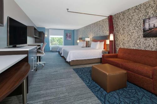 um quarto de hotel com uma cama e um sofá em Home2 Suites Smithfield Providence em Smithfield