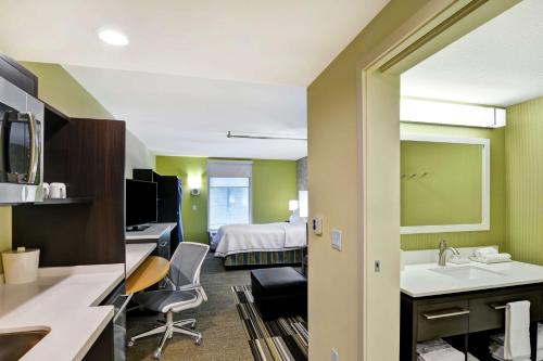 a bathroom with a sink and a bed in a room at Home2 Suites By Hilton Hilton Head in Hilton Head Island