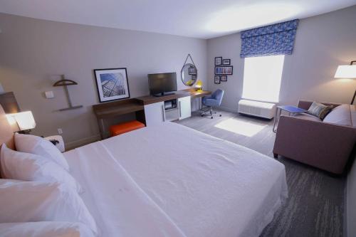a hotel room with a white bed and a desk at Hampton Inn & Suites Forest City in Forest City