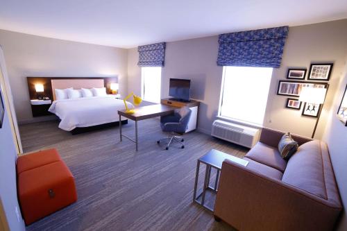 a hotel room with a bed and a desk at Hampton Inn & Suites Forest City in Forest City