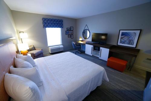 a hotel room with a white bed and a desk at Hampton Inn & Suites Forest City in Forest City