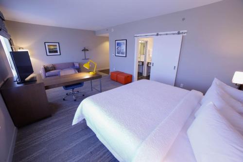 a hotel room with a white bed and a desk at Hampton Inn & Suites Forest City in Forest City
