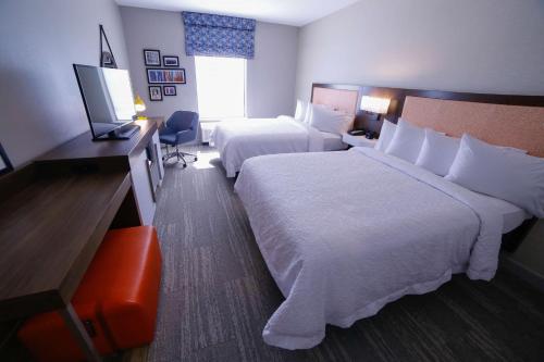 a hotel room with two beds and a desk at Hampton Inn & Suites Forest City in Forest City