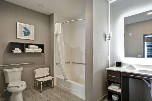 a bathroom with a shower and a toilet and a sink at Homewood Suites by Hilton Conroe in Conroe